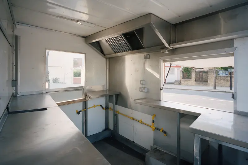 Food truck în construcție, cu blaturi din inox, hotă și instalație de gaz